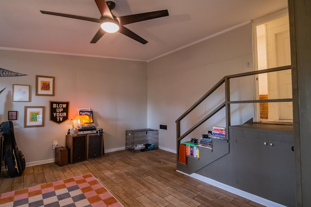  - living room featuring wood finished floors, ceiling fan, crown molding, and stairs