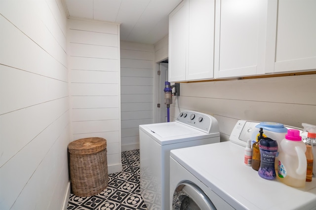  - laundry room with independent washer and dryer, cabinet space, and wood walls