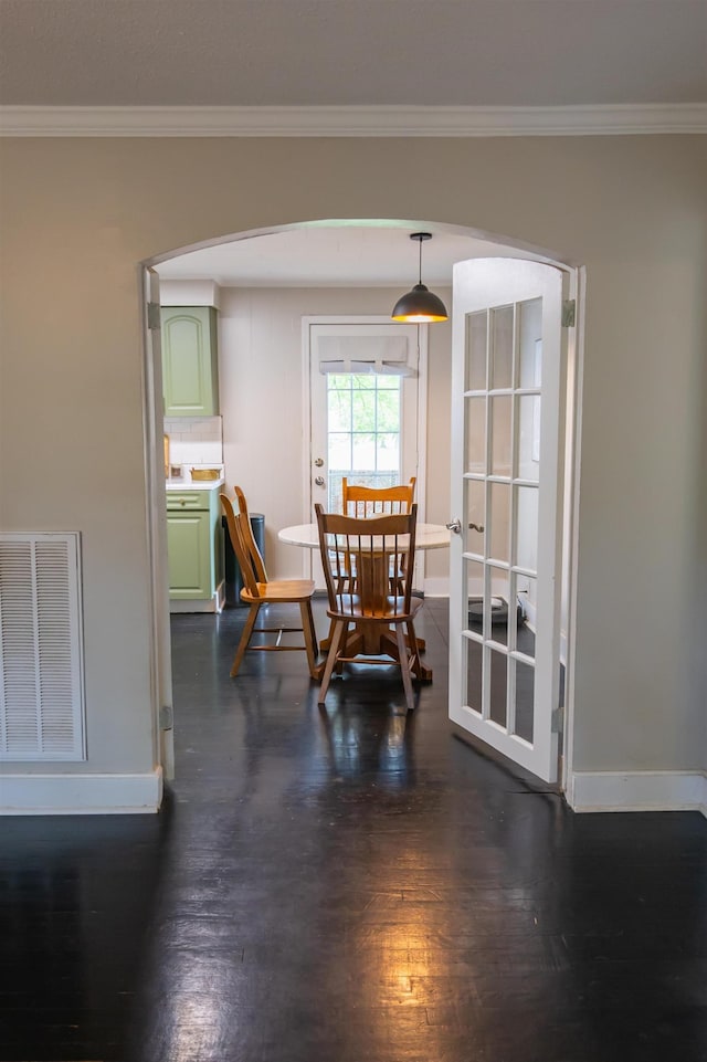 - dining area featuring arched walkways, ornamental molding, and dark wood-style floors
