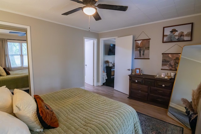  - bedroom with crown molding, wood finished floors, and ceiling fan
