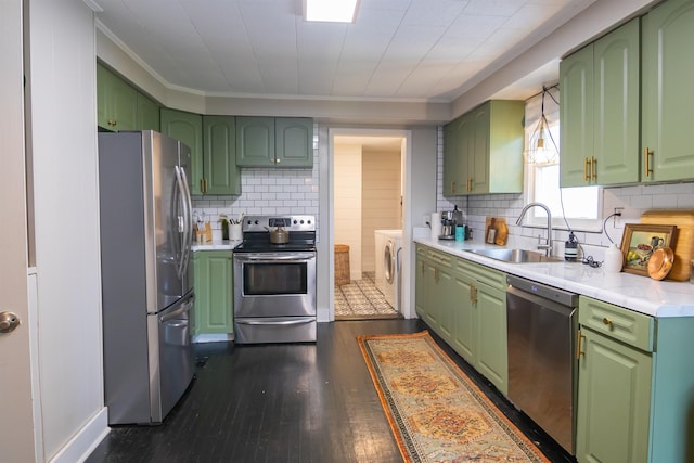  - kitchen with appliances with stainless steel finishes, green cabinets, washer and dryer, and ornamental molding