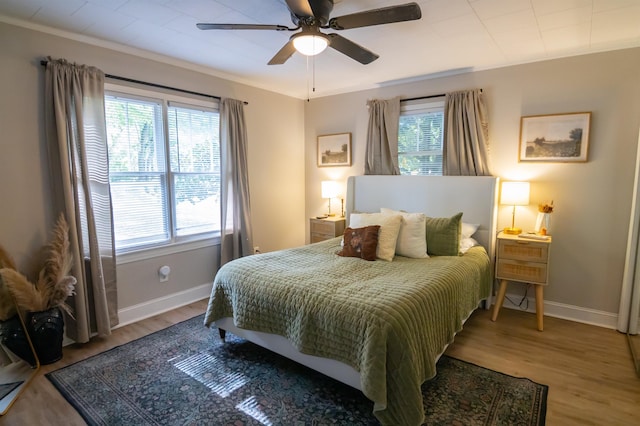  - bedroom featuring wood finished floors, ceiling fan, and crown molding