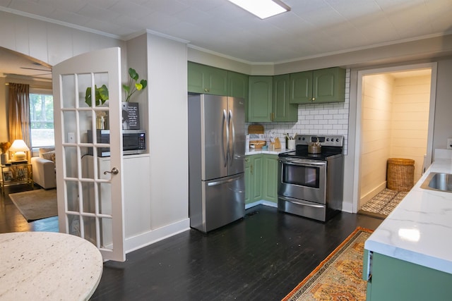  - kitchen with appliances with stainless steel finishes, green cabinetry, ornamental molding, dark wood finished floors, and tasteful backsplash