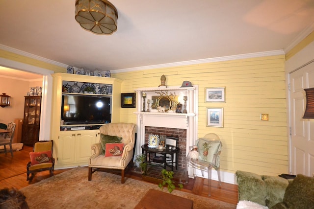 living room featuring crown molding, a brick fireplace, and hardwood / wood-style flooring