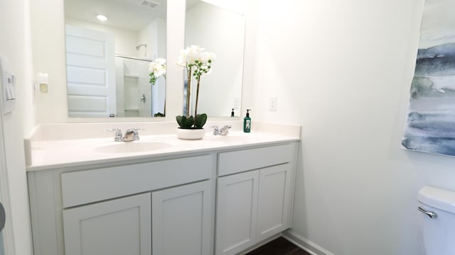  - bathroom featuring double vanity, toilet, and a shower