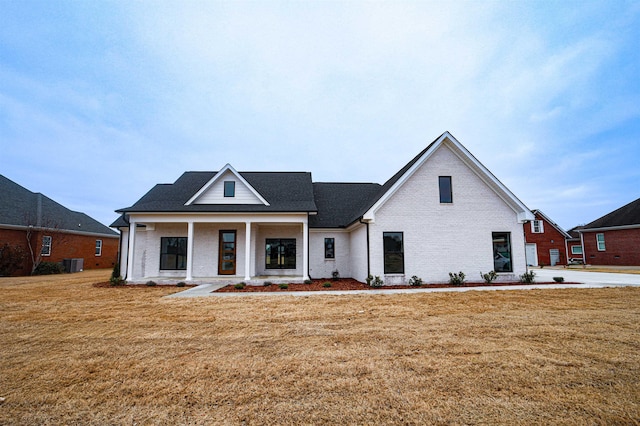 view of front of house featuring central AC unit, a porch, and a front yard