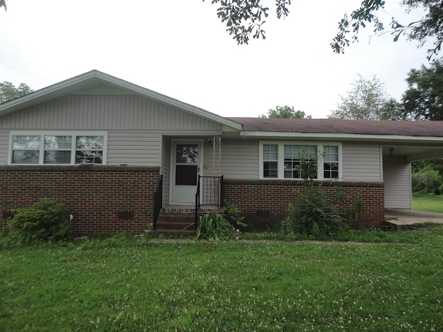 - view of front of property with brick siding, a front lawn, and an attached carport