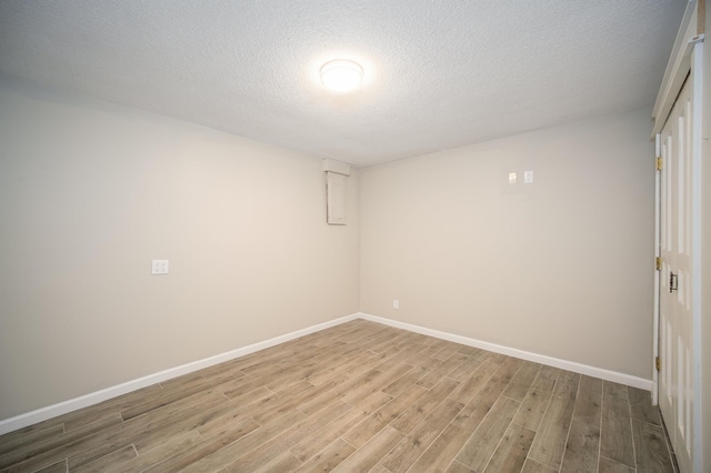 empty room with wood-type flooring and a textured ceiling