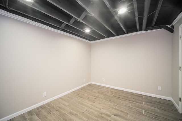 basement featuring crown molding and hardwood / wood-style flooring