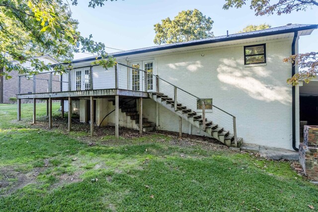 back of house featuring a wooden deck, a yard, and french doors