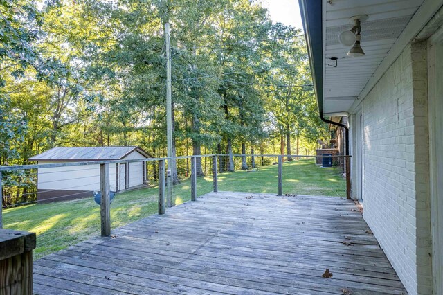 deck featuring a yard, a garage, an outdoor structure, and central air condition unit