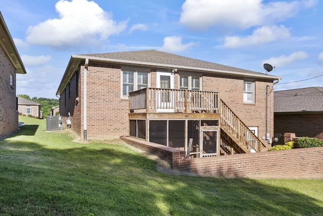 back of house featuring central AC unit, a sunroom, a wooden deck, and a lawn