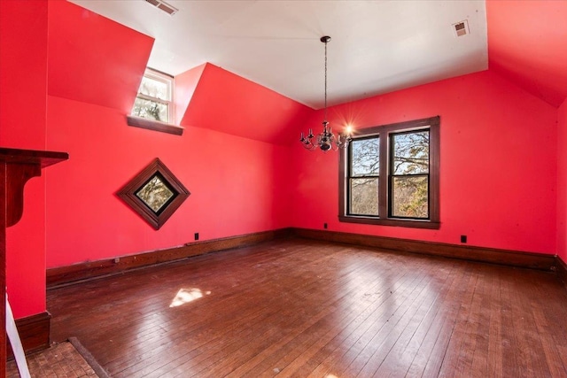 unfurnished dining area featuring an inviting chandelier, vaulted ceiling, a wealth of natural light, and dark hardwood / wood-style flooring