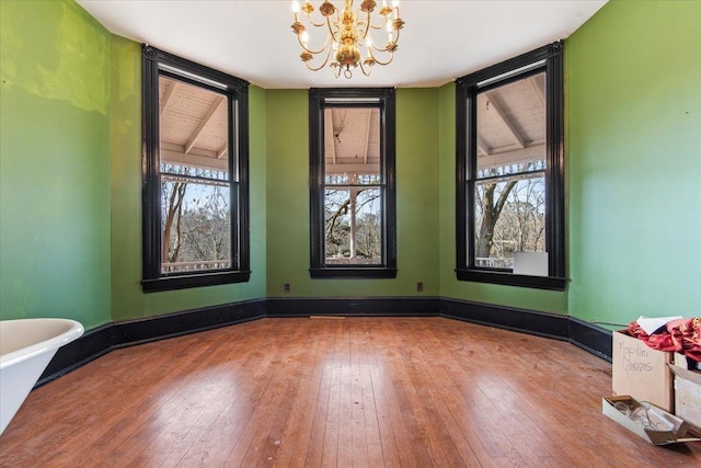 unfurnished room featuring wood-type flooring and a chandelier