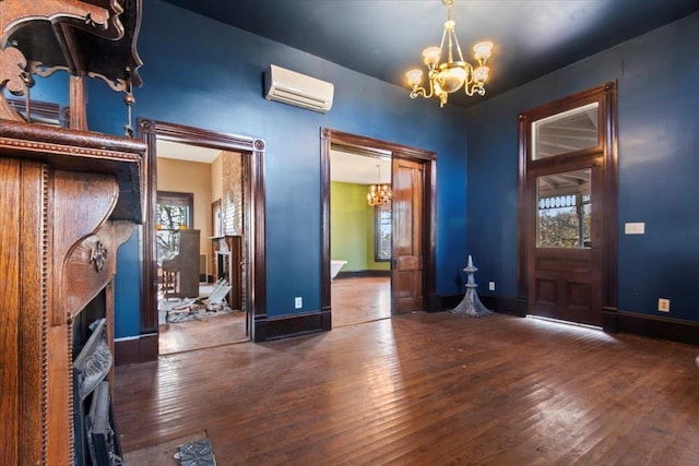 foyer entrance with dark hardwood / wood-style floors, a wall mounted AC, and a chandelier