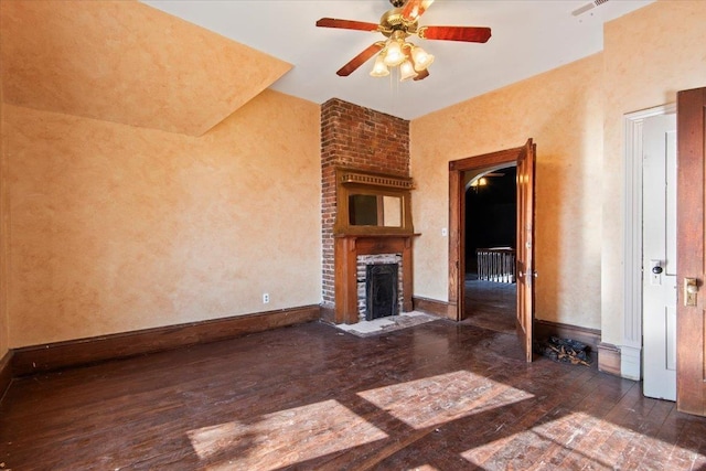 unfurnished living room featuring dark wood-type flooring, ceiling fan, and a fireplace