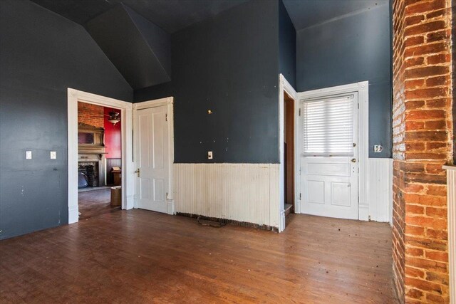 foyer entrance with hardwood / wood-style flooring and vaulted ceiling