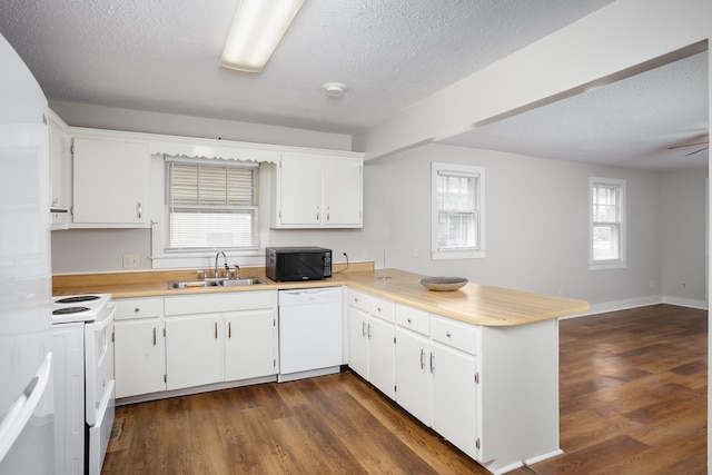 kitchen featuring sink, white appliances, kitchen peninsula, and white cabinets