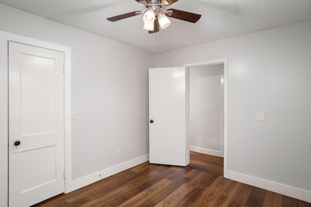 unfurnished bedroom with ceiling fan, dark wood-type flooring, and a textured ceiling