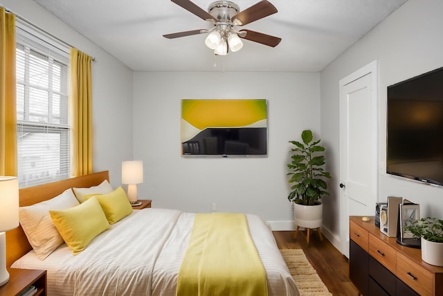 bedroom with dark hardwood / wood-style flooring and ceiling fan