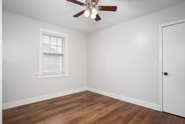 empty room with ceiling fan, dark hardwood / wood-style flooring, and a textured ceiling