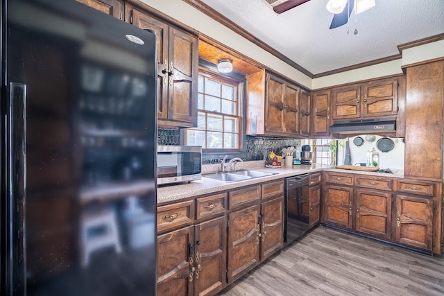  - kitchen featuring freestanding refrigerator, stainless steel microwave, dishwasher, ornamental molding, and light countertops