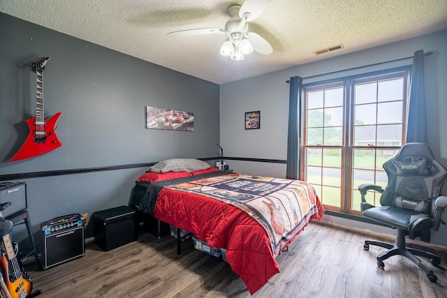  - bedroom with a textured ceiling, wood finished floors, and a ceiling fan