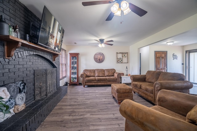  - living area with a fireplace, ceiling fan, and wood finished floors