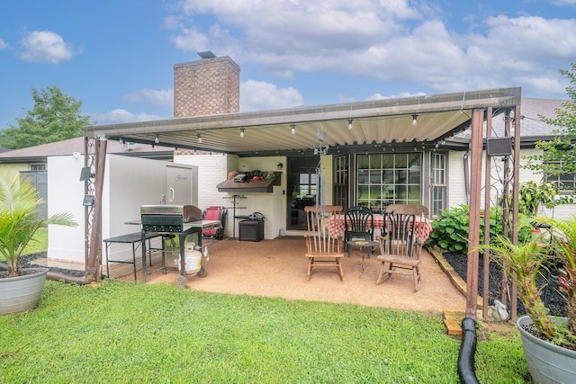  - rear view of house featuring a chimney, a patio area, and a yard