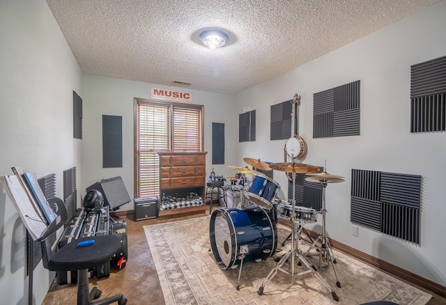  - game room featuring a textured ceiling and baseboards