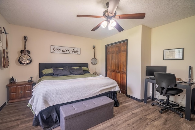  - bedroom with wood finished floors, a closet, a desk, ceiling fan, and a textured ceiling