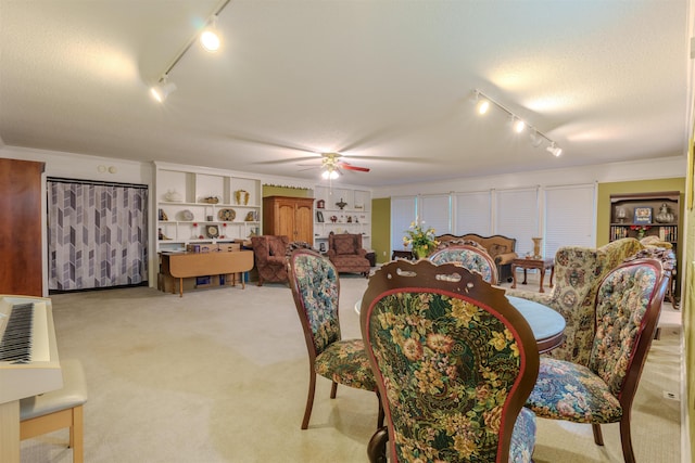 carpeted dining space featuring ceiling fan and a textured ceiling