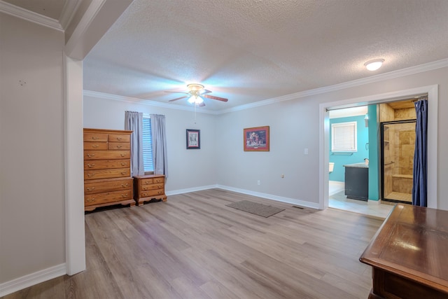 unfurnished bedroom featuring ensuite bath, ornamental molding, a textured ceiling, and light wood-type flooring