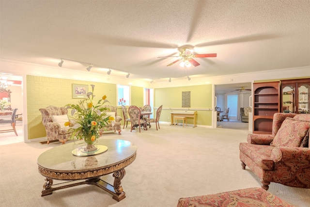 living room with ceiling fan, rail lighting, light colored carpet, and a textured ceiling