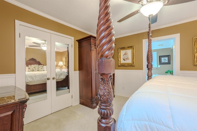 carpeted bedroom featuring crown molding, ceiling fan, a textured ceiling, and french doors