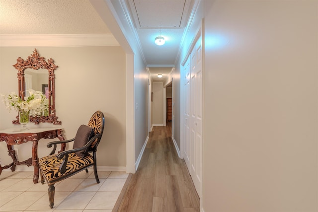 hallway featuring crown molding, a textured ceiling, and light wood-type flooring