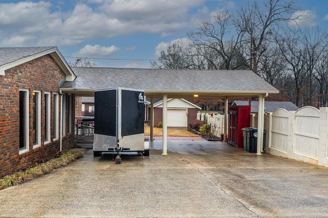 exterior space featuring a garage, a carport, and an outbuilding