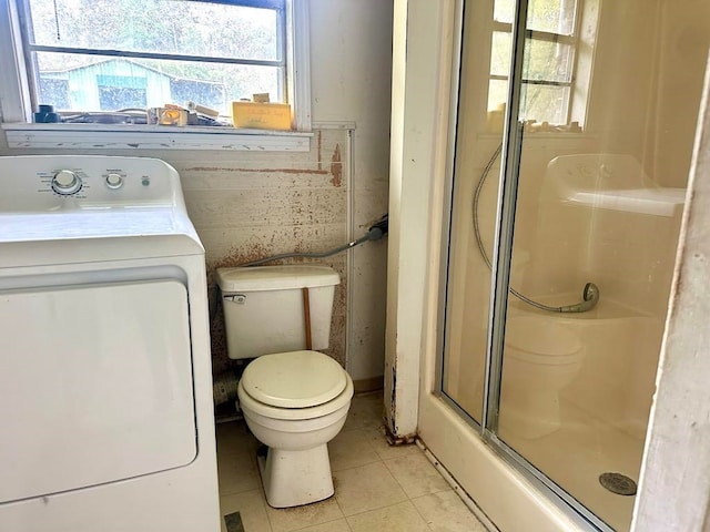 bathroom featuring washer / clothes dryer, toilet, tile patterned flooring, and walk in shower