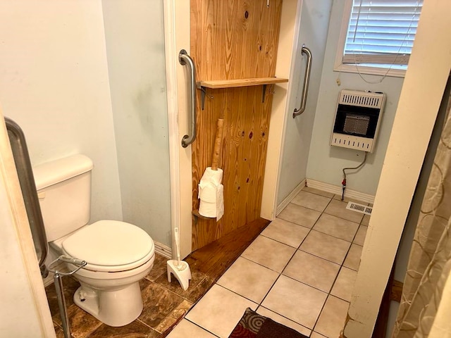 bathroom featuring tile patterned flooring, toilet, and heating unit