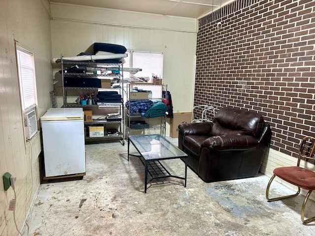 living room featuring concrete floors and brick wall