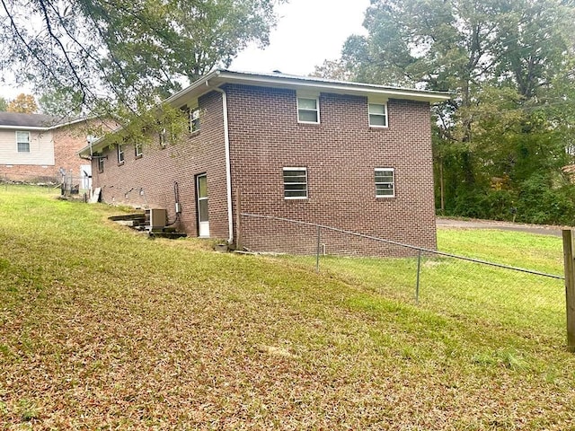 view of side of home with a yard and central AC unit