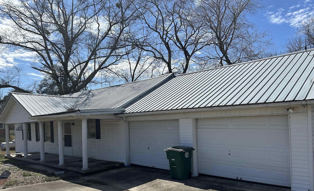 view of property exterior featuring an attached garage, a standing seam roof, and metal roof