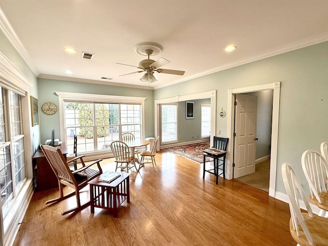 interior space with crown molding, light hardwood / wood-style floors, and ceiling fan