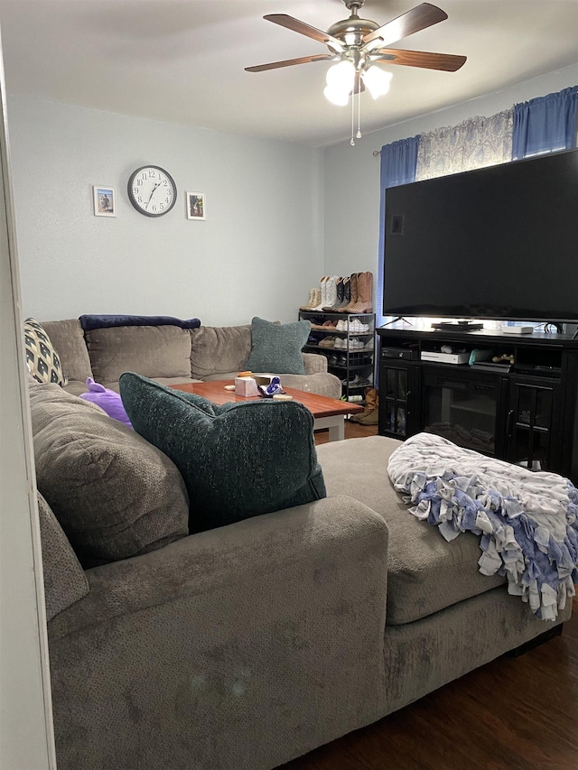 living room with ceiling fan and dark wood-type flooring