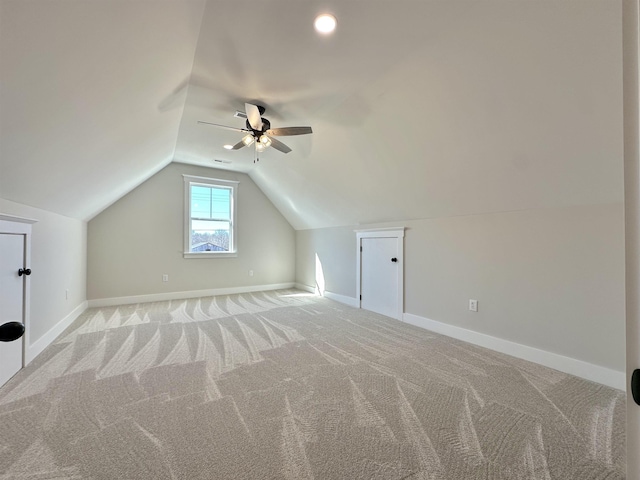 bonus room with lofted ceiling and light colored carpet