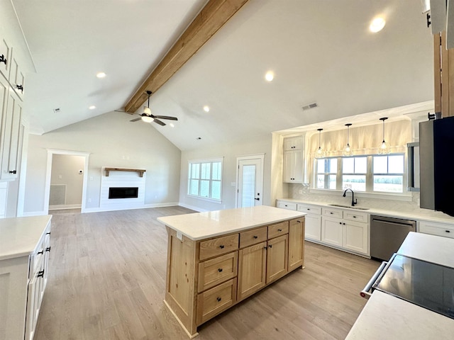 kitchen with pendant lighting, sink, light hardwood / wood-style floors, a kitchen island, and stainless steel dishwasher