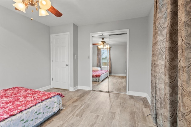  - bedroom with wood finished floors, a closet, baseboards, and ceiling fan