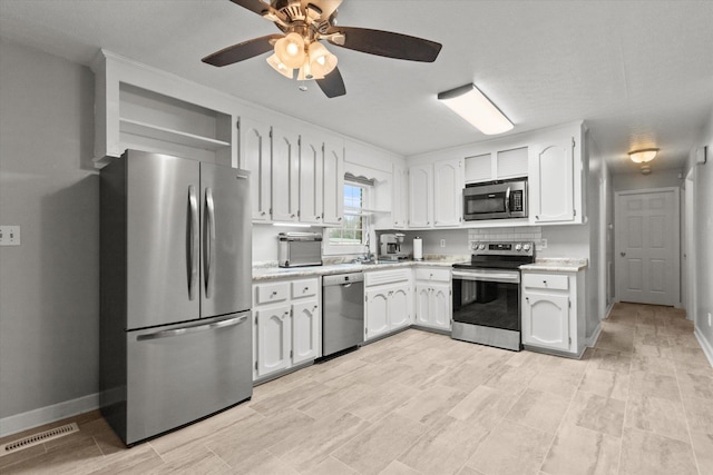  - kitchen with appliances with stainless steel finishes, light countertops, and white cabinetry