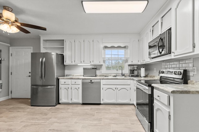 - kitchen with appliances with stainless steel finishes, open shelves, a sink, white cabinets, and a ceiling fan