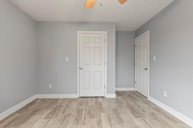  - spare room with wood tiled floors, a ceiling fan, and baseboards